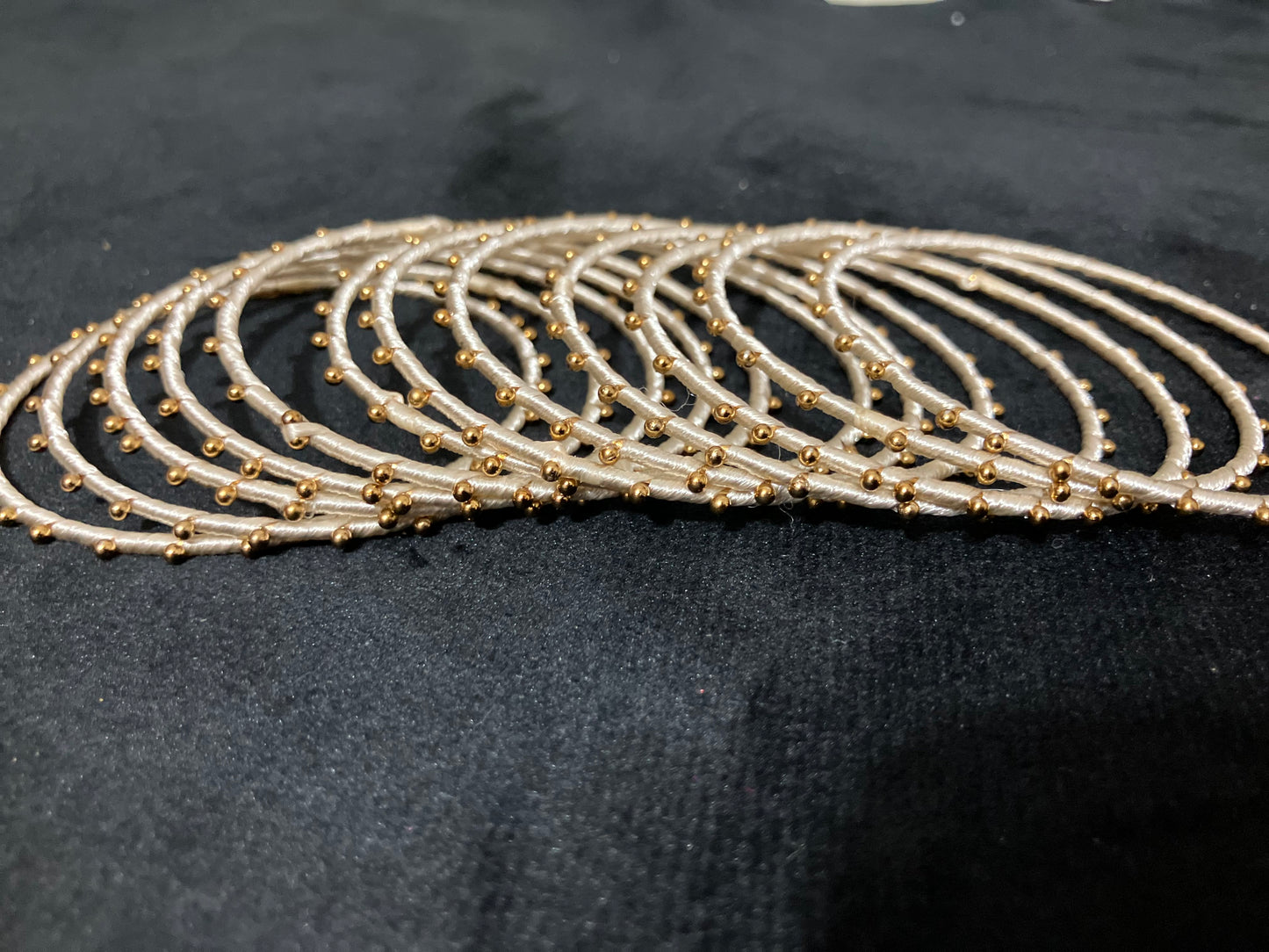 Silk Thread-wrapped metal bangles featuring gold-toned balls