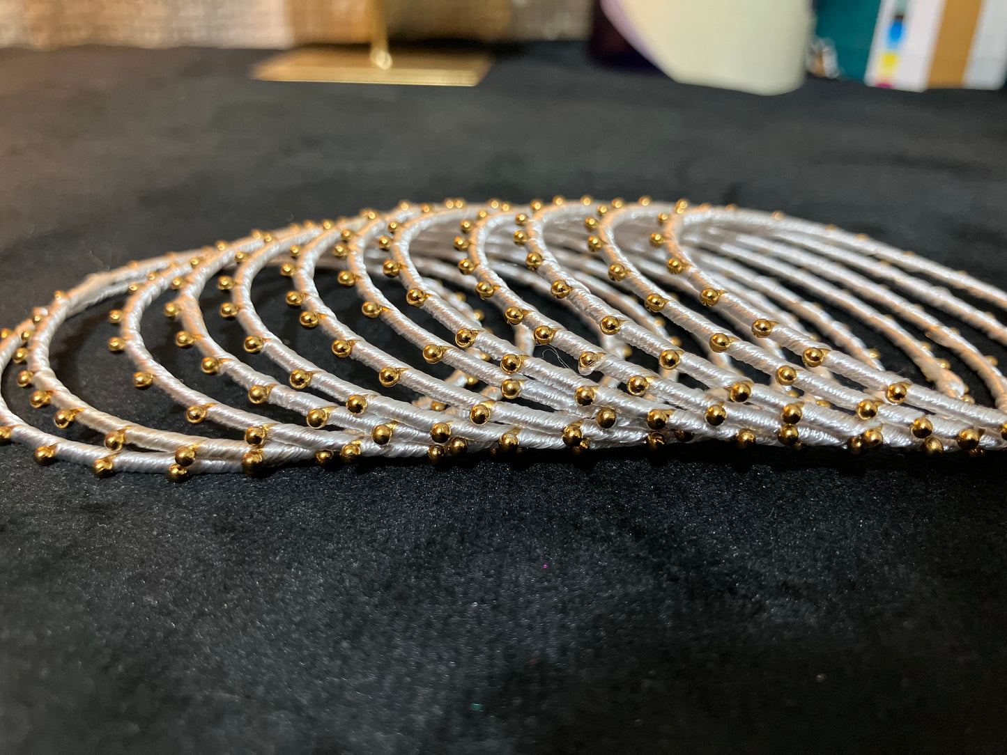 Silk Thread-wrapped metal bangles featuring gold-toned balls