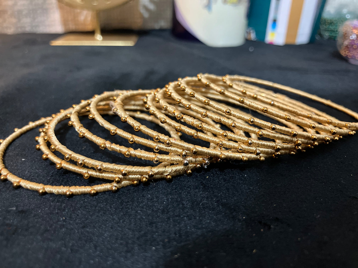 Silk Thread-wrapped metal bangles featuring gold-toned balls