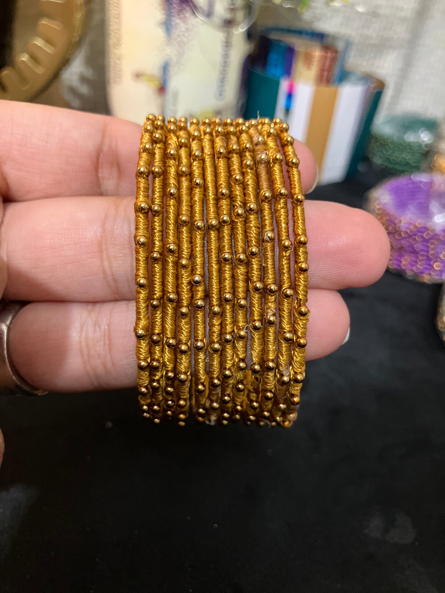 Silk Thread-wrapped metal bangles featuring gold-toned balls
