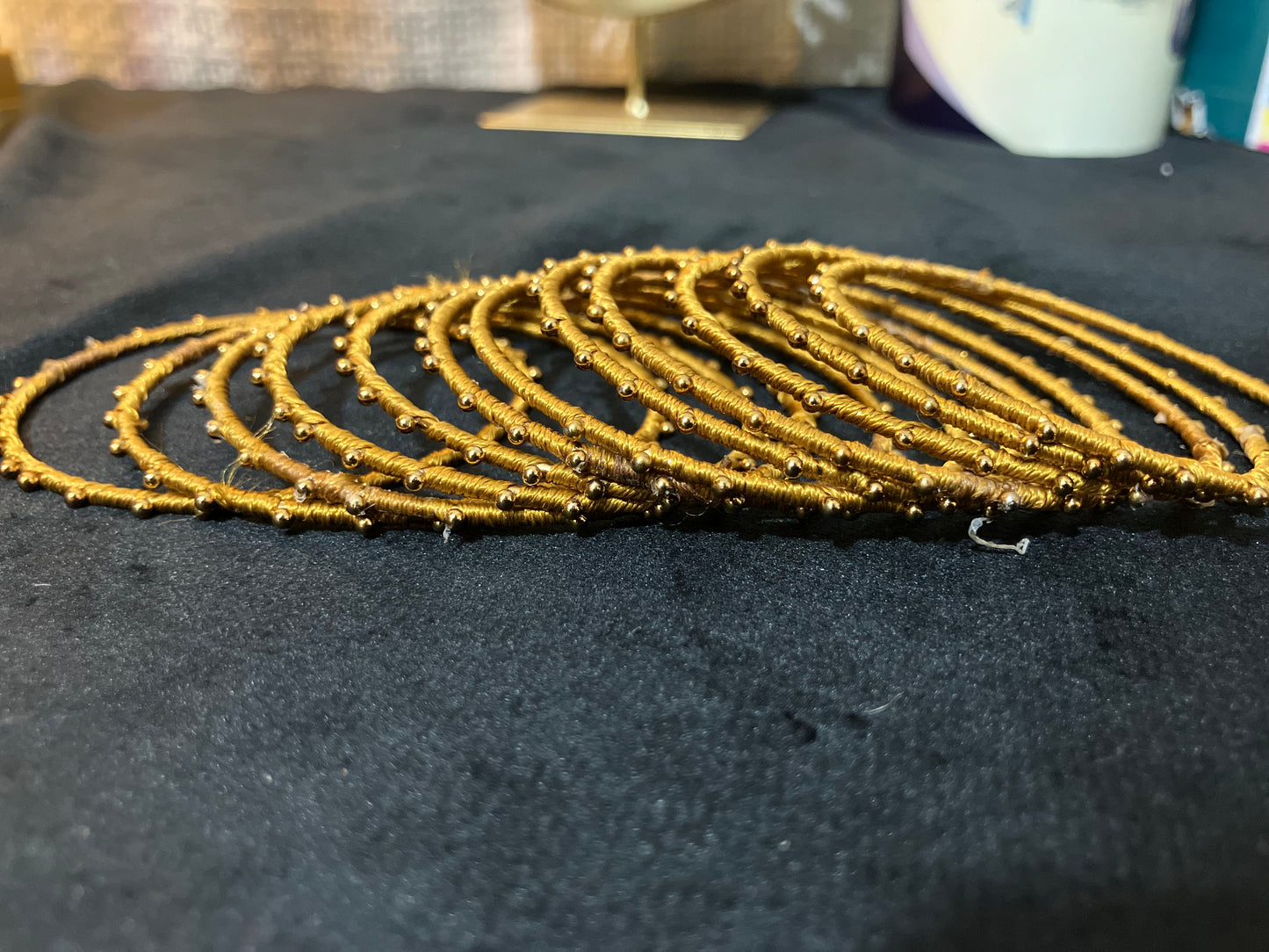 Silk Thread-wrapped metal bangles featuring gold-toned balls