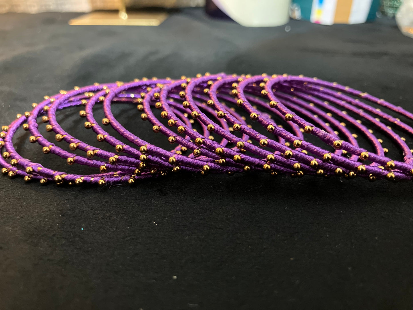 Silk Thread-wrapped metal bangles featuring gold-toned balls