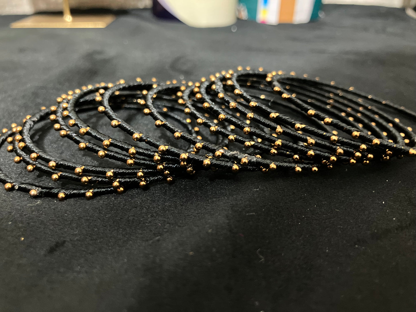 Silk Thread-wrapped metal bangles featuring gold-toned balls